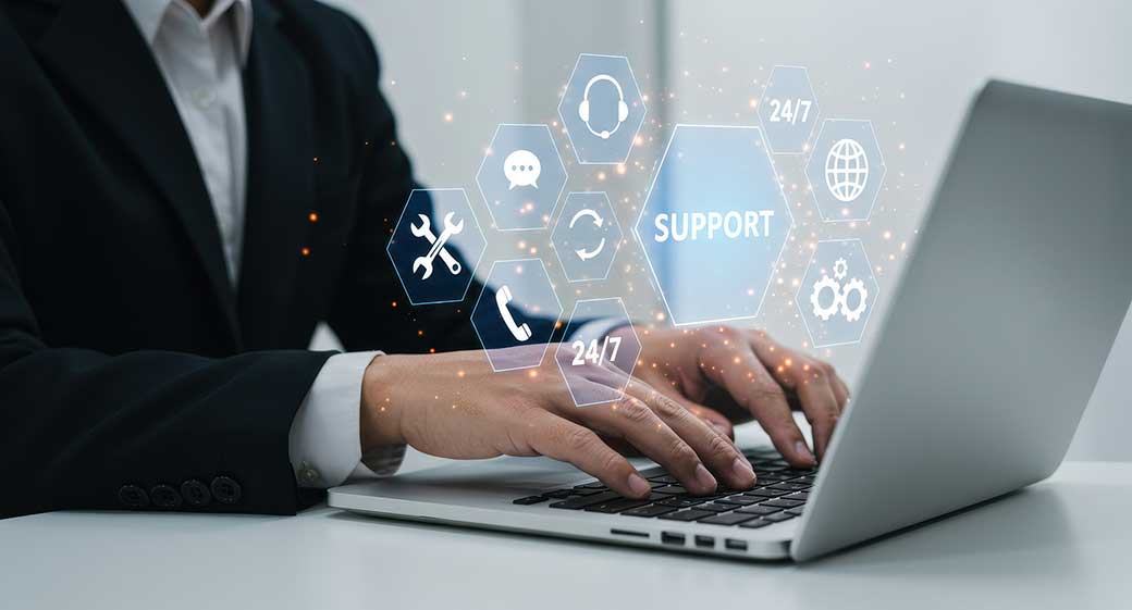 A businessman on aa laptop with it support services at hiss finger tips. 
