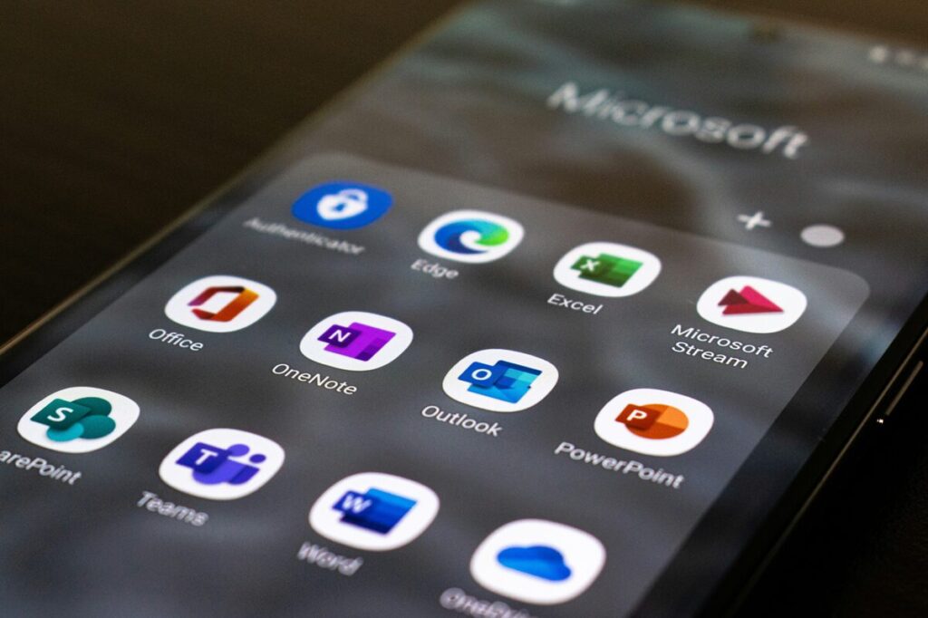 Microsoft app icons displayed on a smartphone screen representing mobile access to AI-powered collaboration.