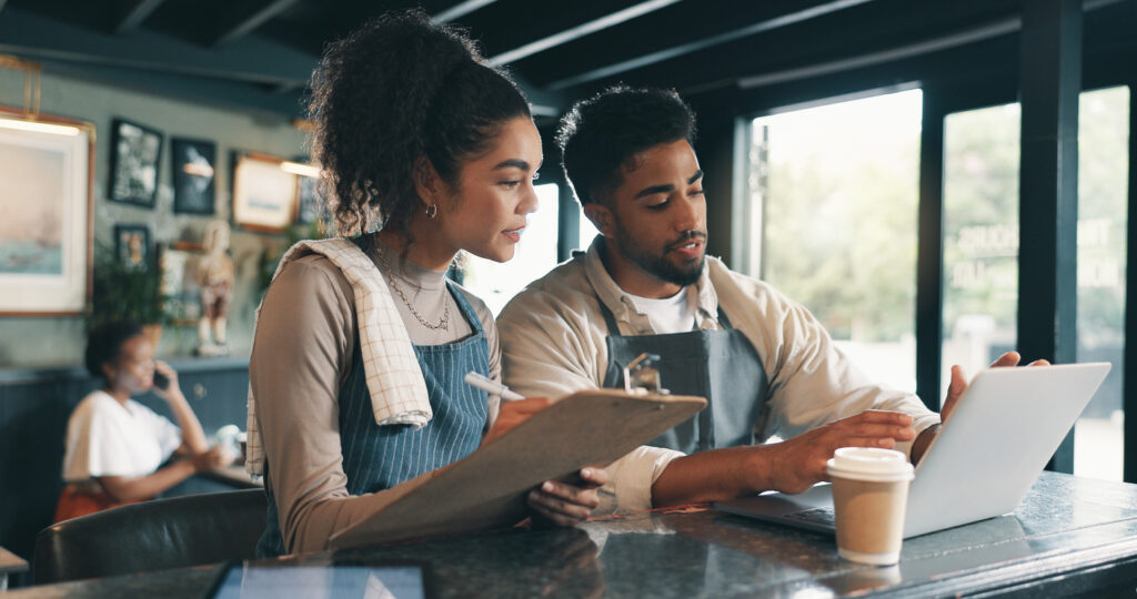 Owners of a small business planning in front of a laptop.