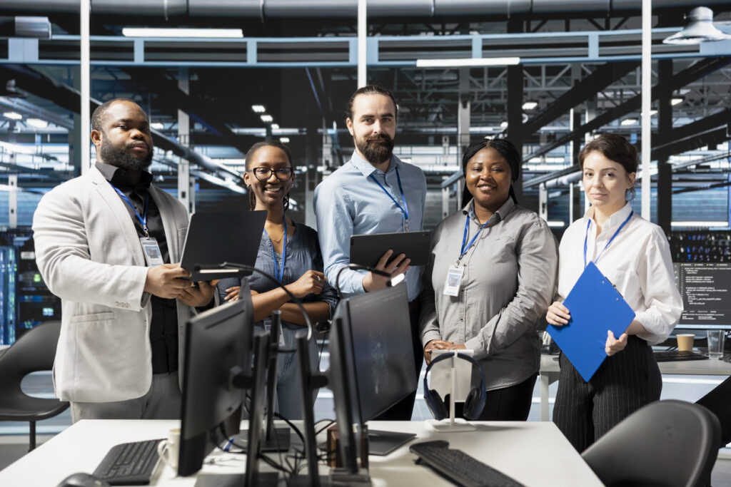 A team of IT professionals in an office around computers.
