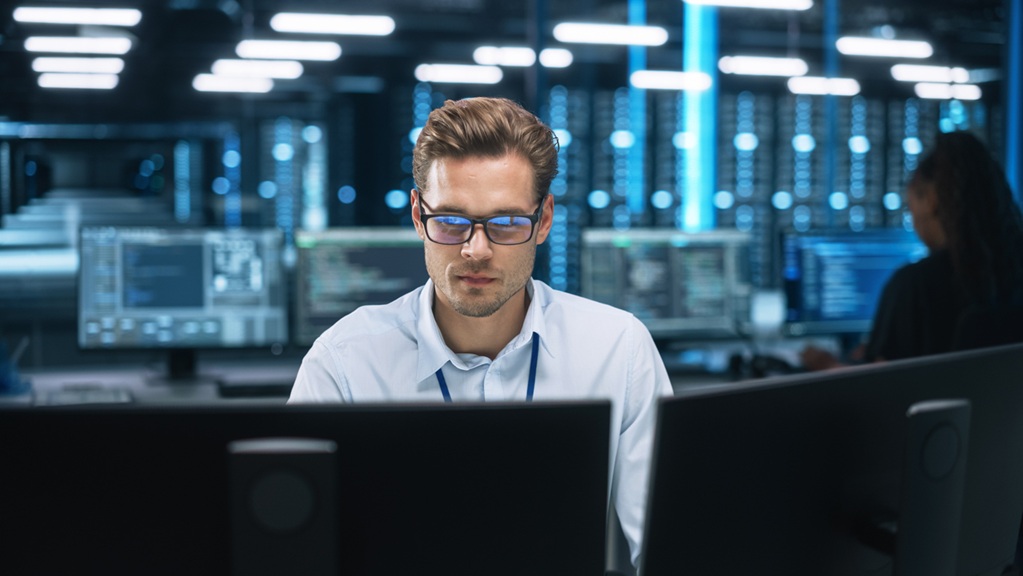 A man sitting in front of a computer at a local IT services company.