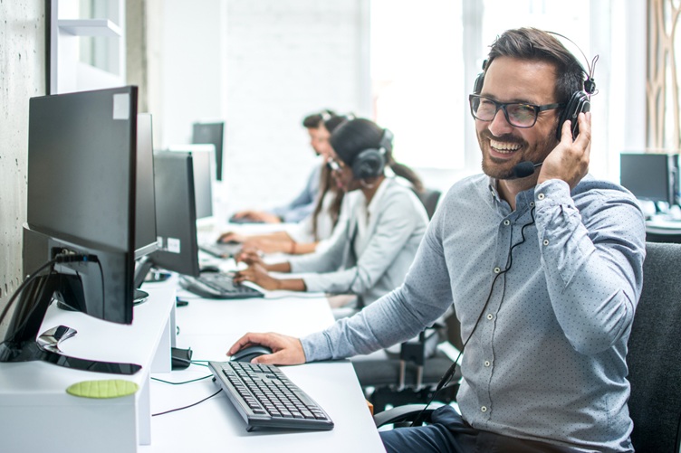 IT customer support operator with headset working in call center.